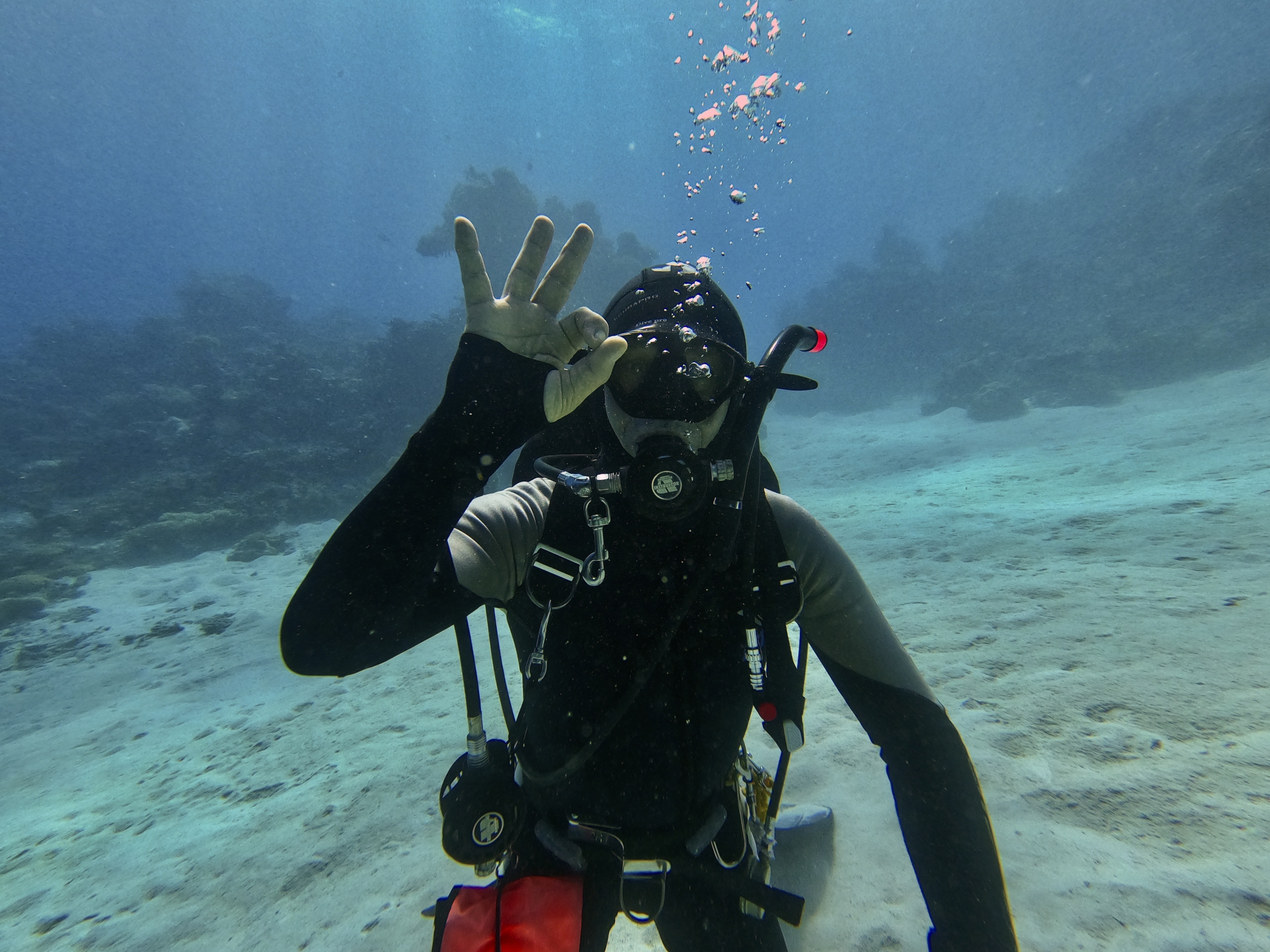 Sam underwater in clear blue water, practising the calm focus that became part of his diving.