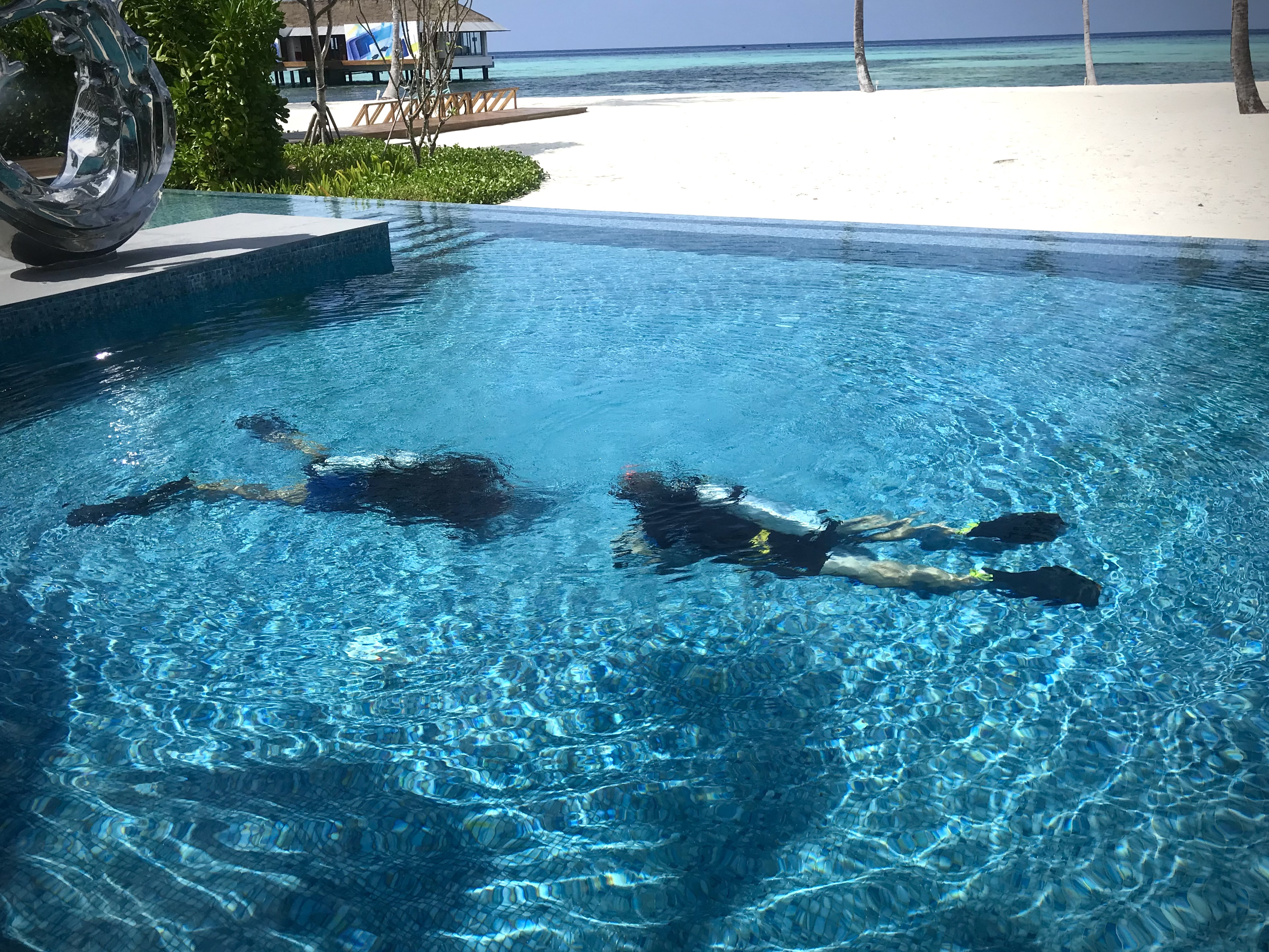 Sam practising early scuba skills in a Maldives pool during Open Water training.