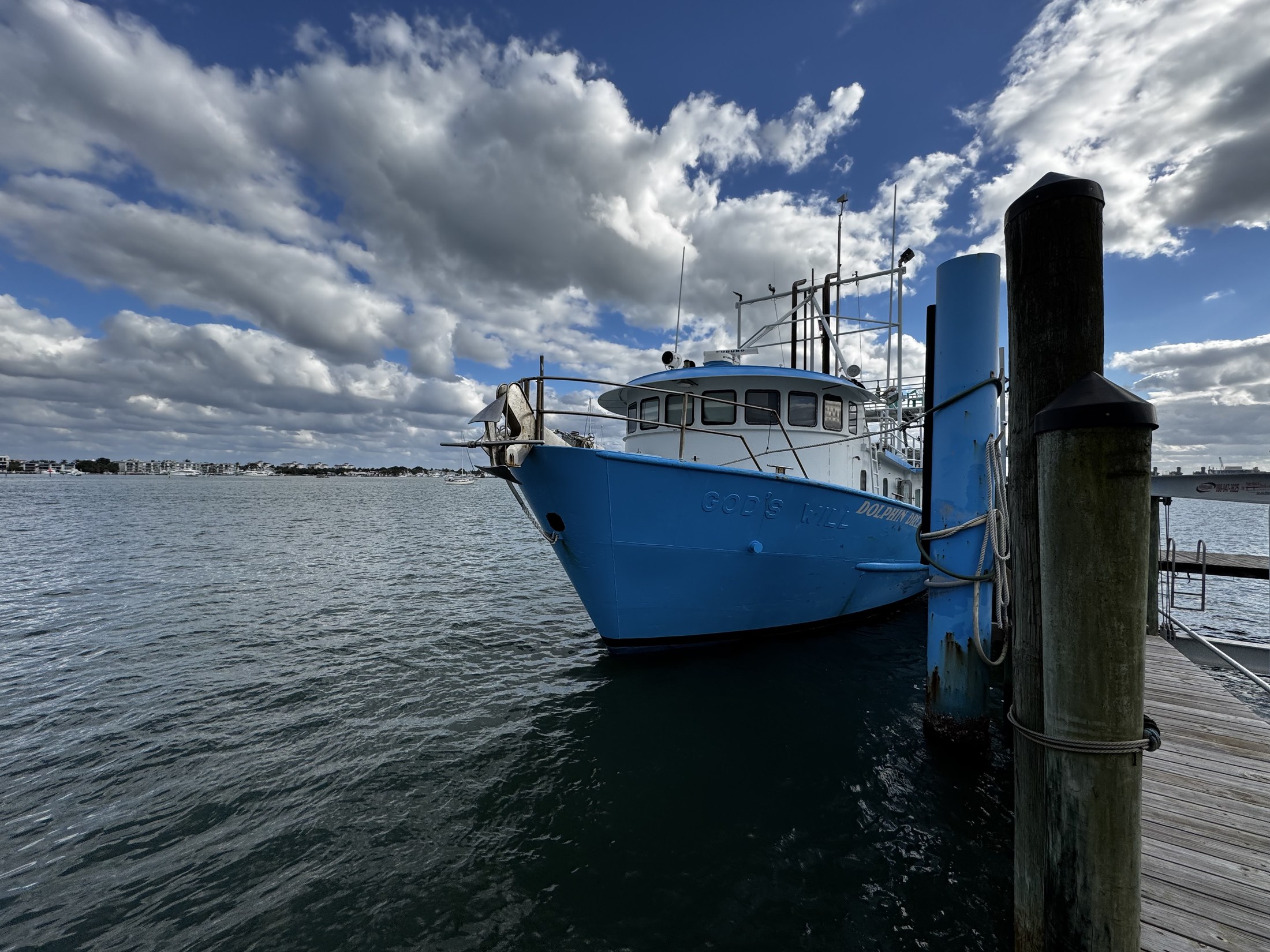 Large clouds over the dock and Dolphin Dream's blue-and-white structure.