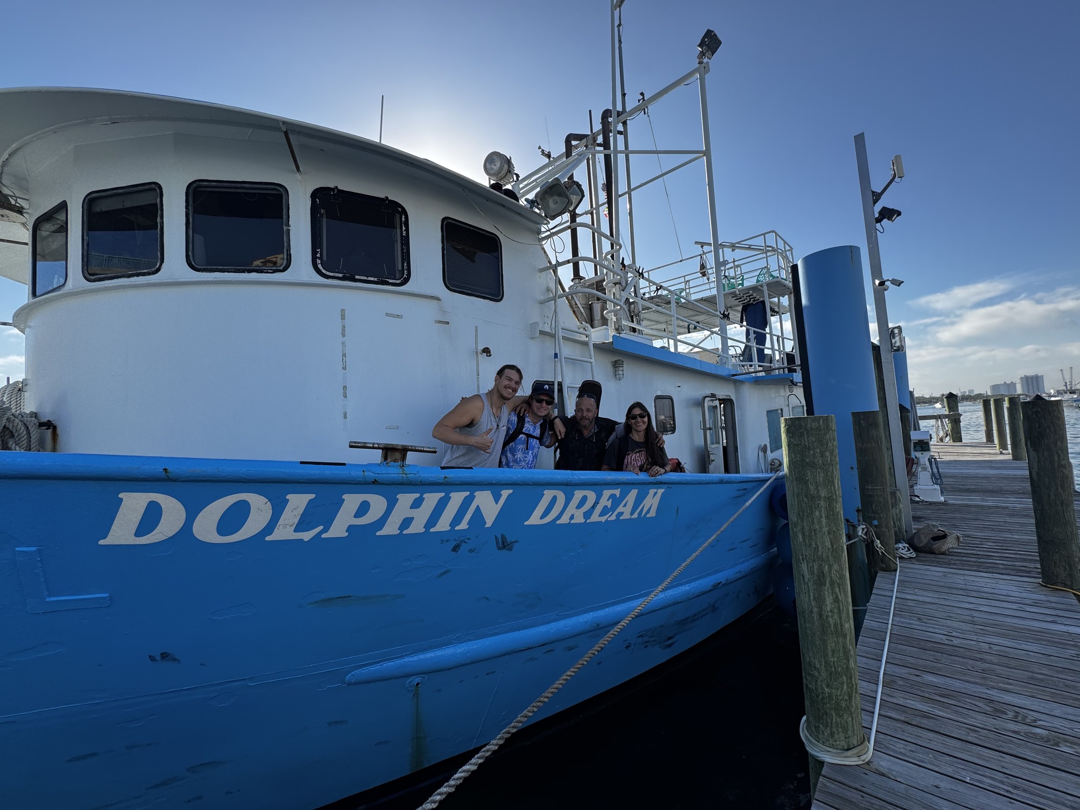 Dolphin Dream moored at the dock with its blue hull visible.