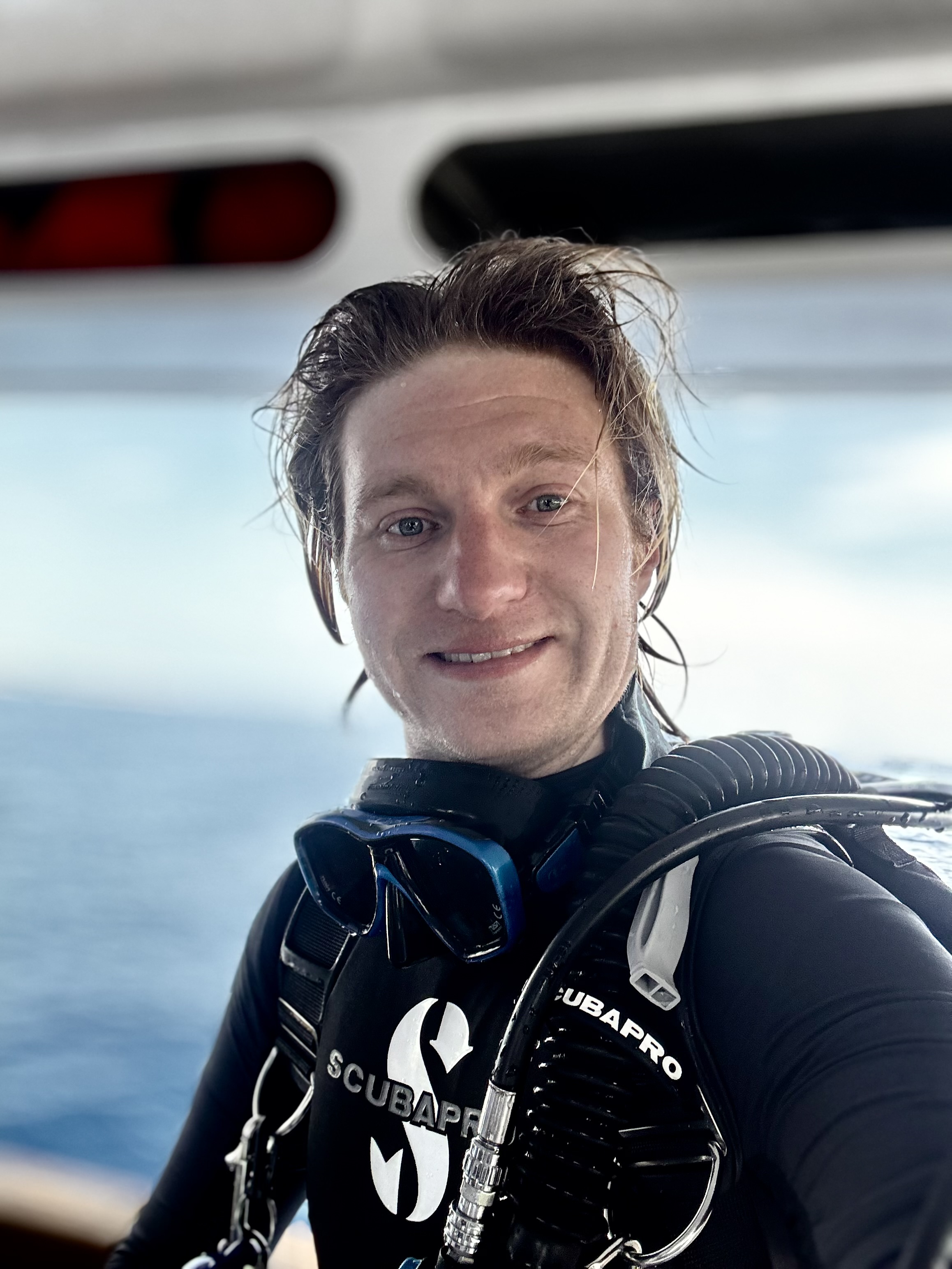 Sam in scuba gear without his mask, ready to dive.